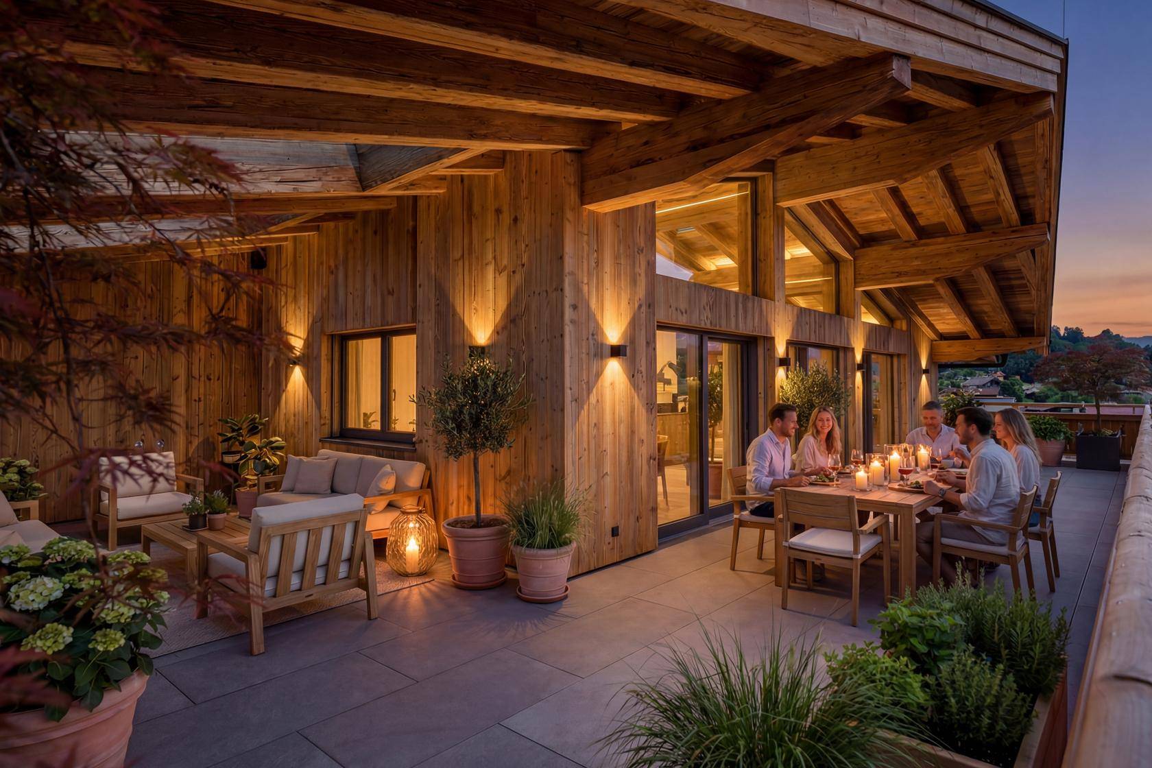 Gemütliche Terrasse am Abend mit stimmungsvoller Beleuchtung, Essbereich und Loungemöbeln, ideal für gesellige Runden.