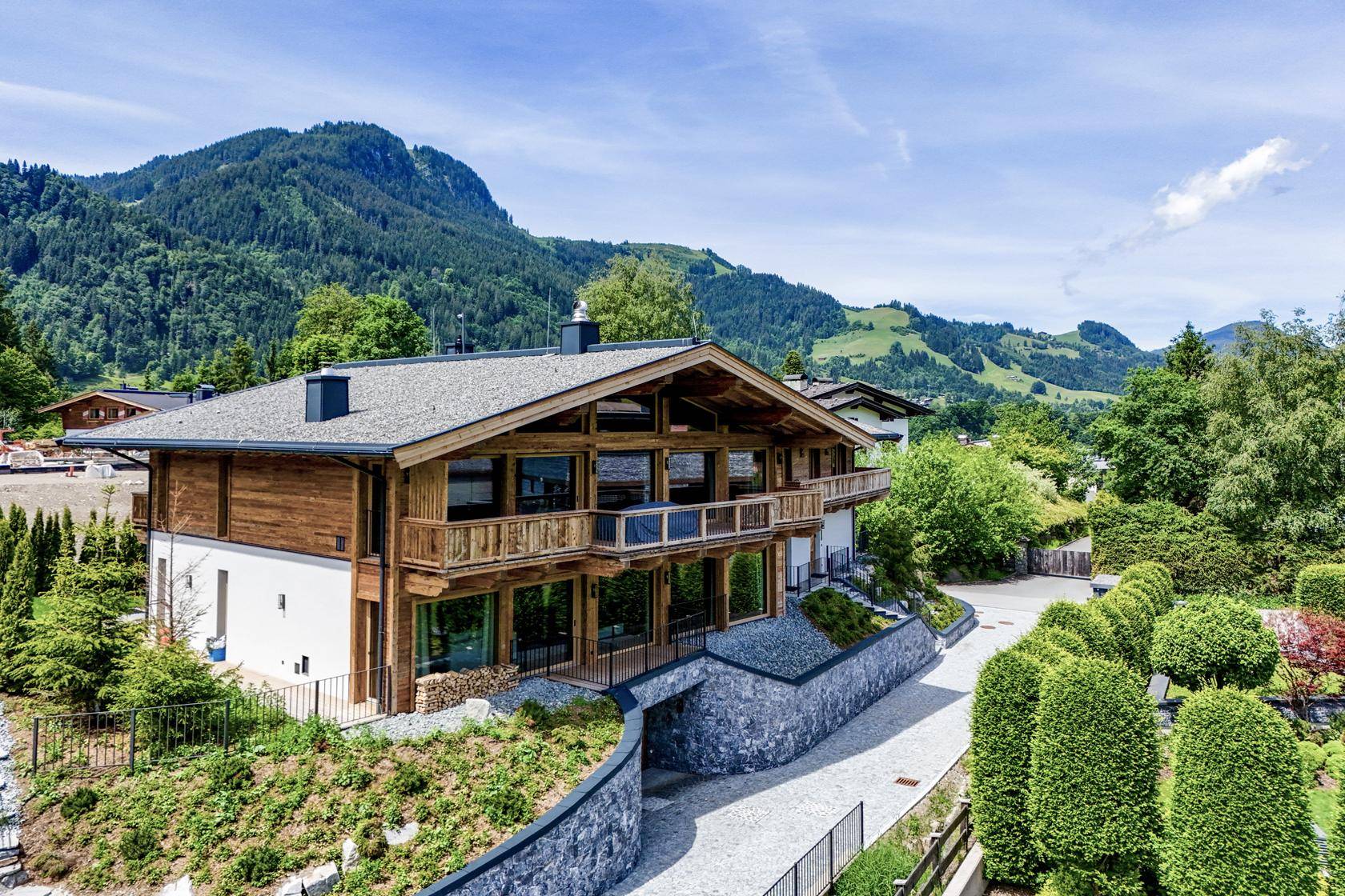 Exklusives Chalet mit Holzfassade und großen Glasflächen, eingebettet in die Berglandschaft.