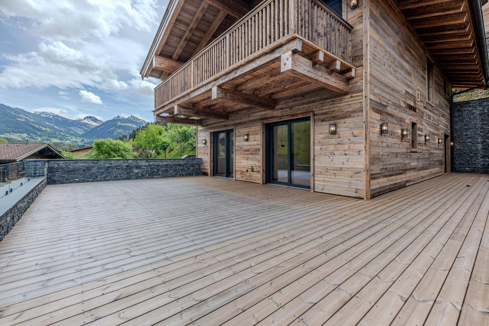 Weitläufige Holzterrasse mit Bergblick, ideal für Entspannung im Freien.