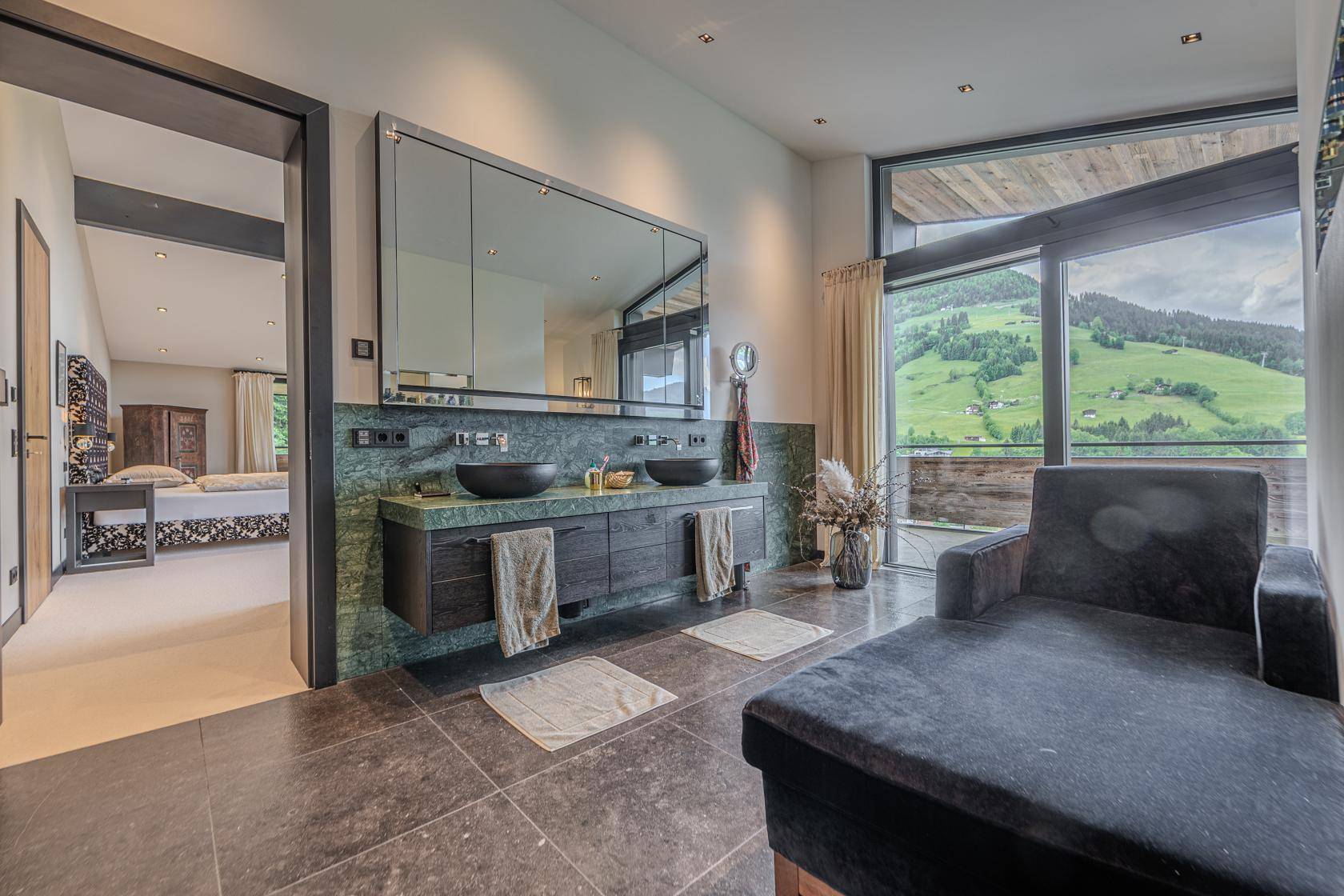 Modernes Badezimmer mit Doppelwaschbecken, großer Spiegelfront und Bergblick.
