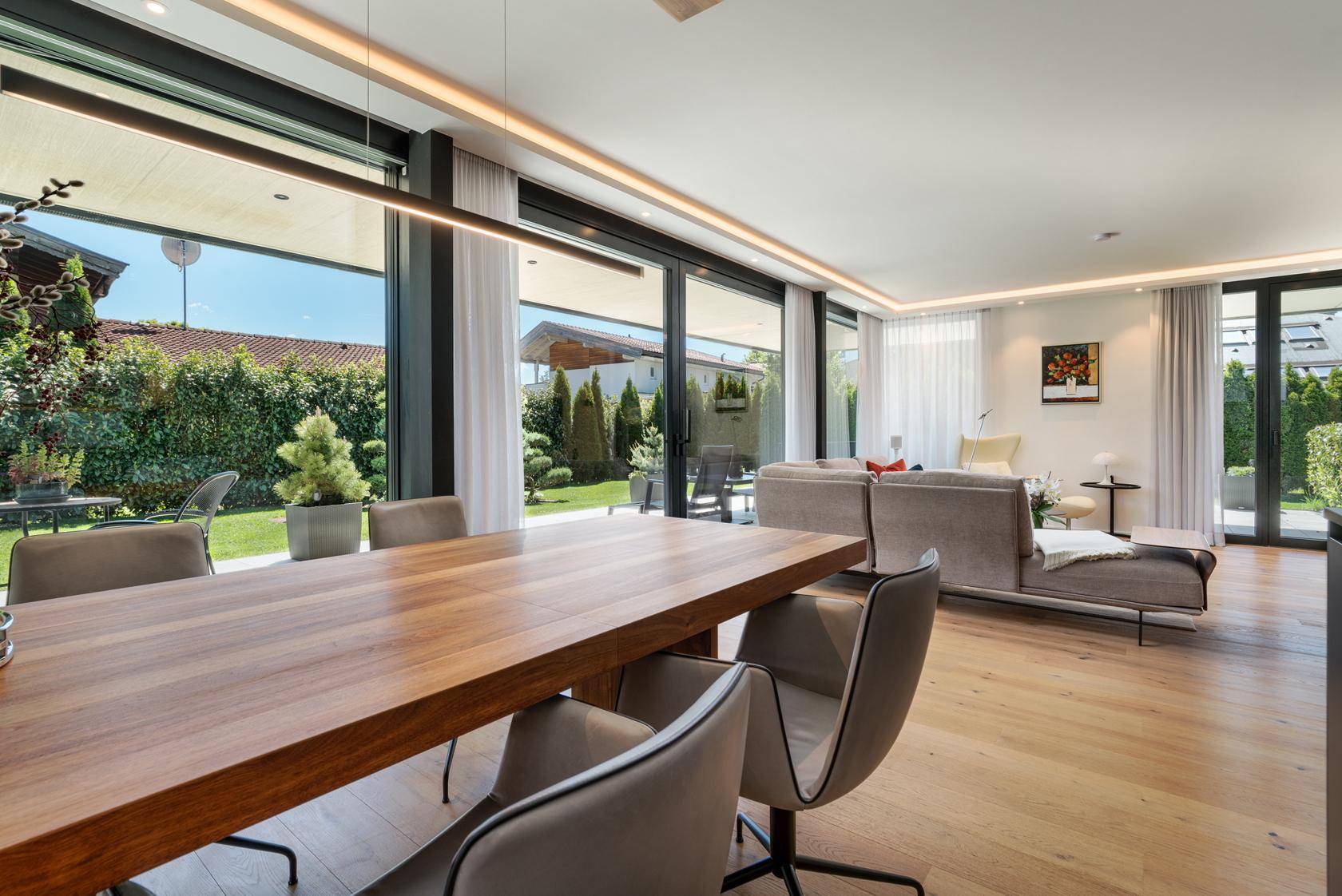 Geräumiger Wohn- und Essbereich mit elegantem Holztisch und Zugang zur Terrasse.
