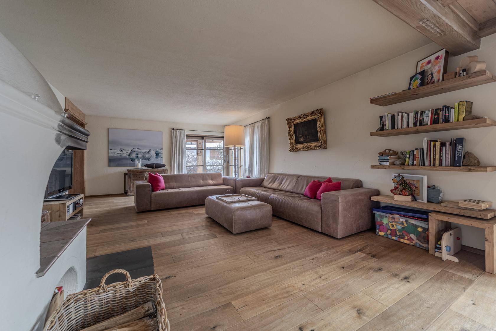 Geräumiges Wohnzimmer mit bequemen Sofas, Holzboden und dekorativen Regalen für Bücher und Deko.
