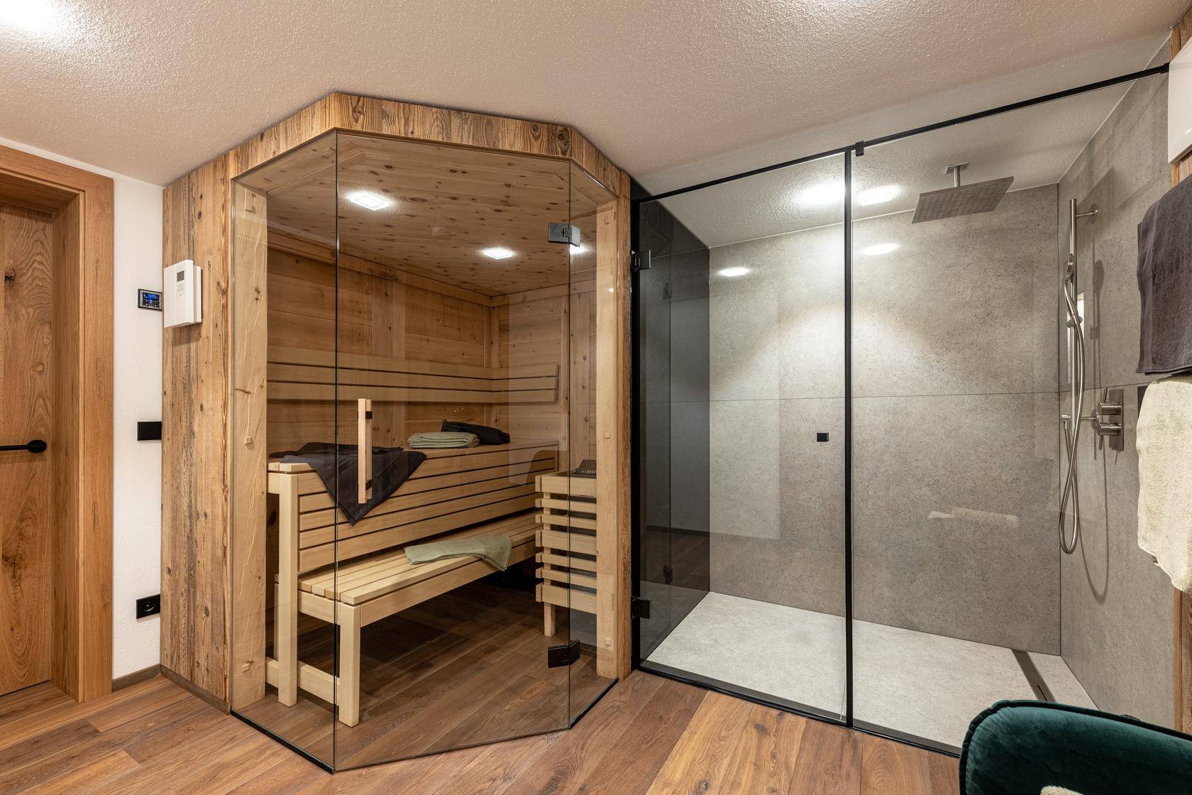 Wellnessbereich mit moderner Sauna, begehbarer Dusche und Holzboden.