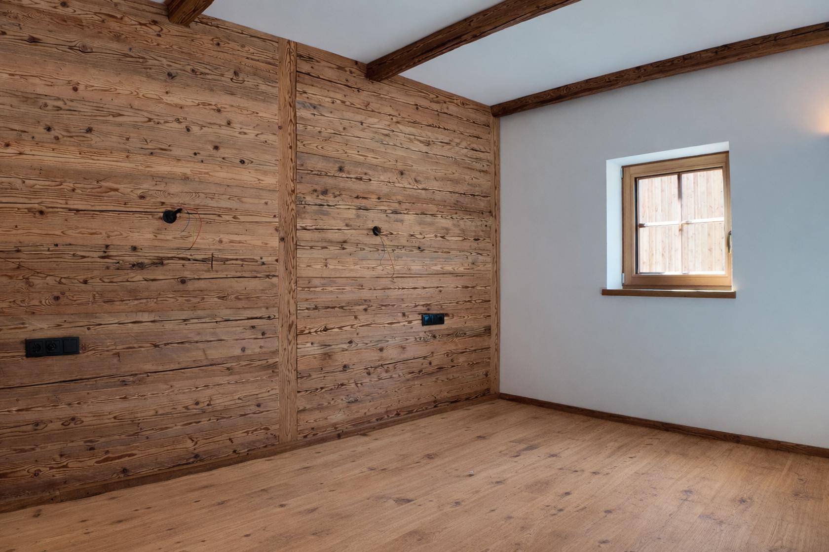 Geräumiges Schlafzimmer mit Holzwand, hellen Wänden und rustikalen Deckenbalken.