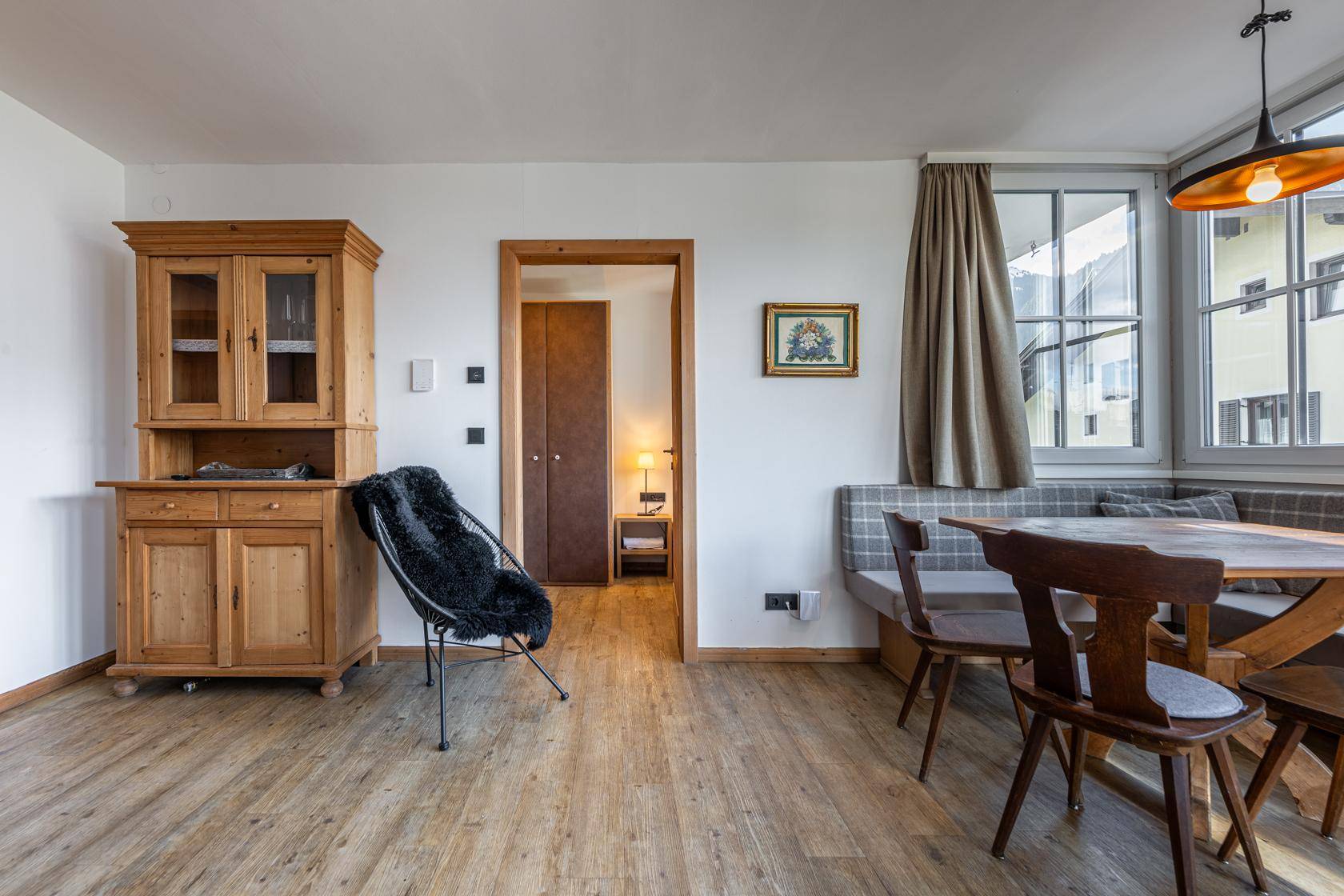 Traditioneller Essbereich mit Holztisch und Eckbank, umgeben von rustikalen Holzmöbeln.