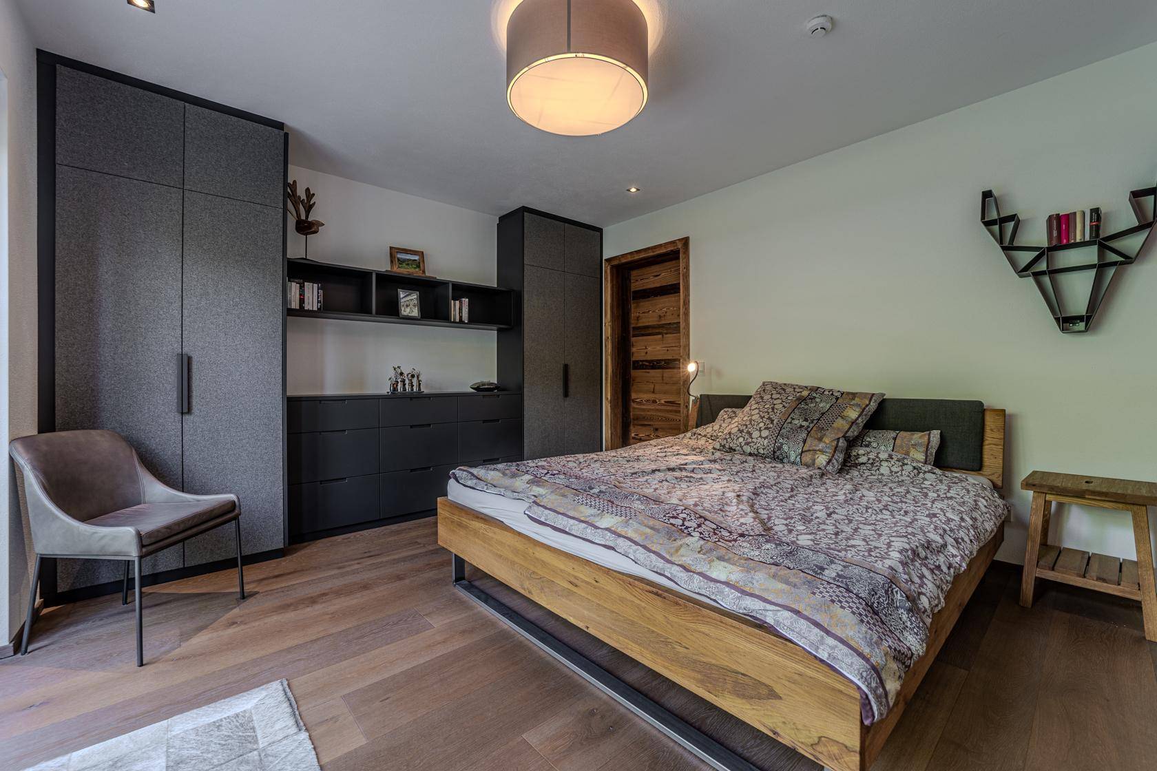 Modernes Schlafzimmer mit Holzbett, Einbauschränken und stilvoller Dekoration.