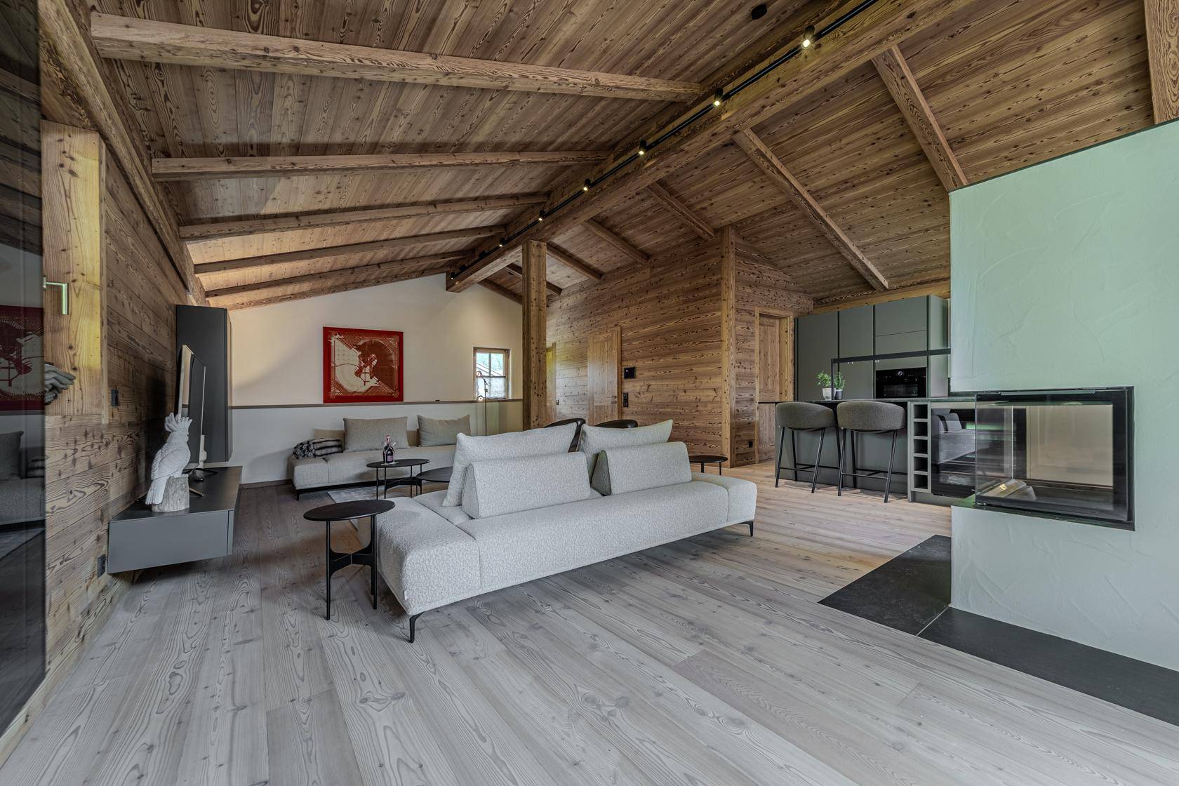 Heller Wohnbereich mit Holzwänden, bequemen Sofas und einem modernen Kamin in offener Gestaltung.