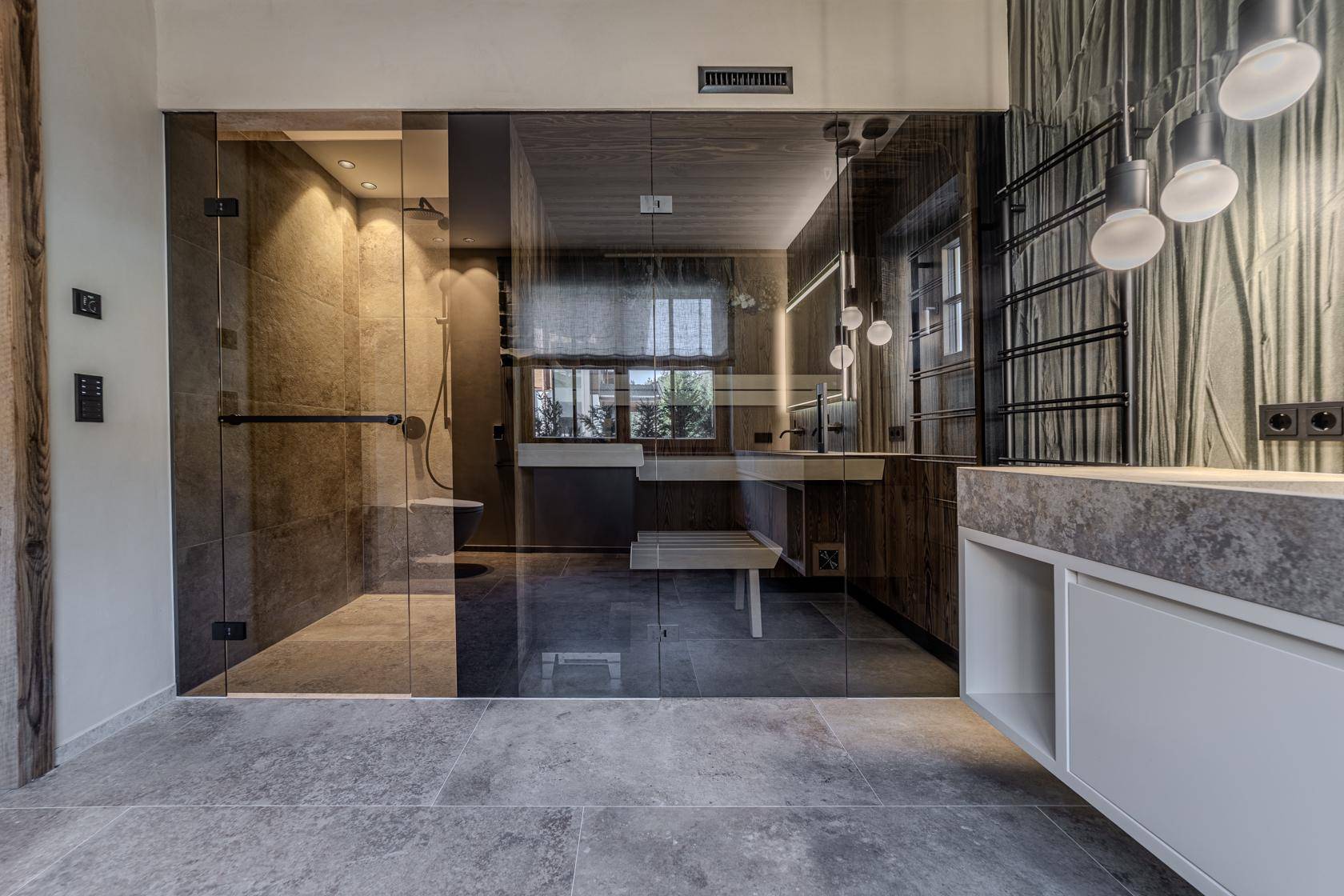 Elegantes Badezimmer mit großer Glasdusche, Doppelwaschbecken und modernen Armaturen.