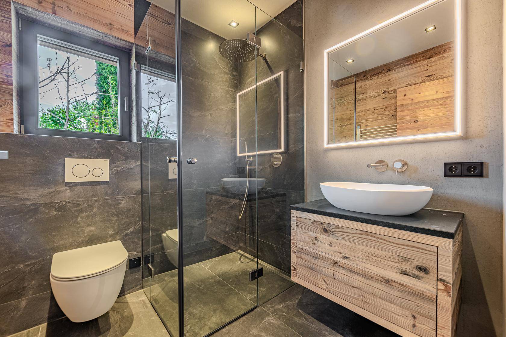 Modernes Badezimmer mit begehbarer Dusche, Wand-WC und stilvollem Waschtisch.