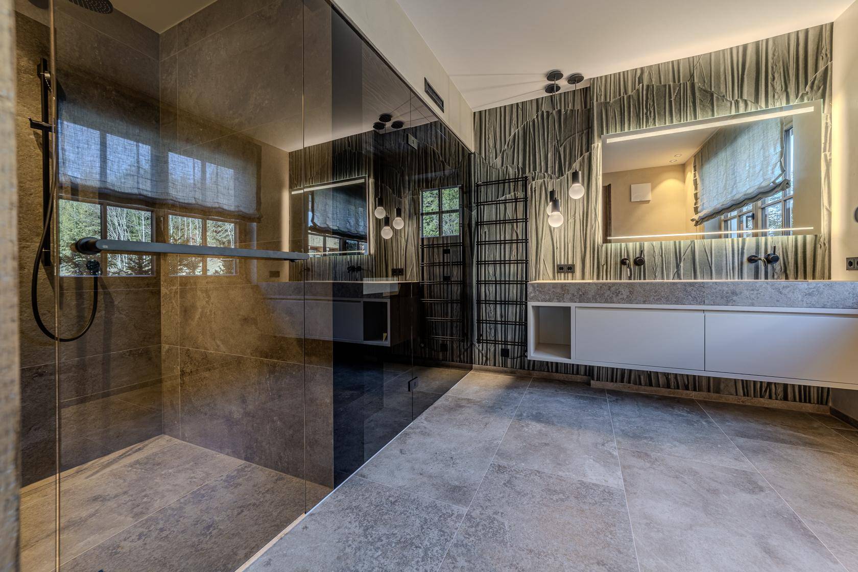 Modernes Badezimmer mit großer begehbarer Dusche, Doppelwaschbecken und stilvoller Beleuchtung.