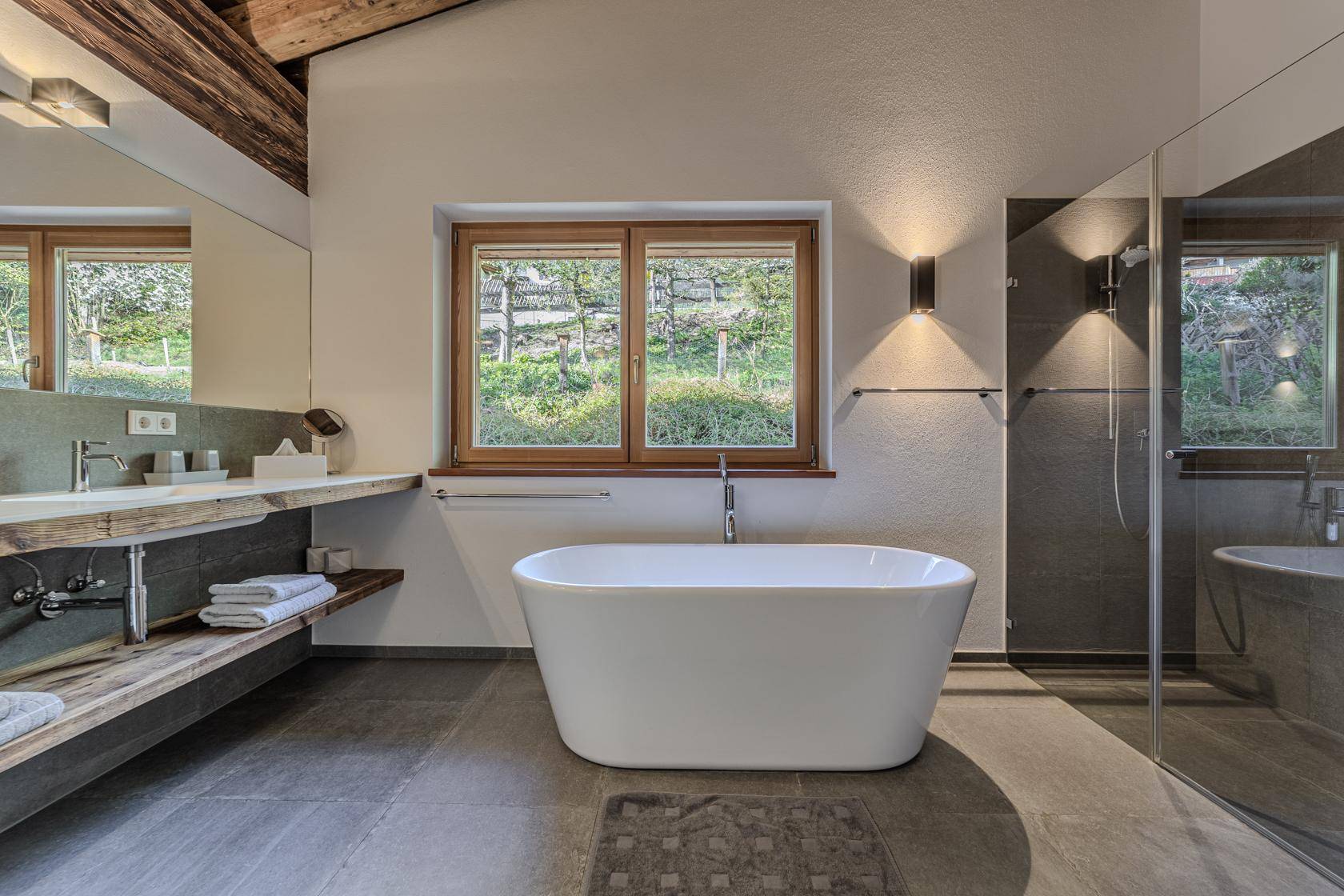 Modernes Badezimmer mit freistehender Badewanne, begehbarer Dusche und Fenster.