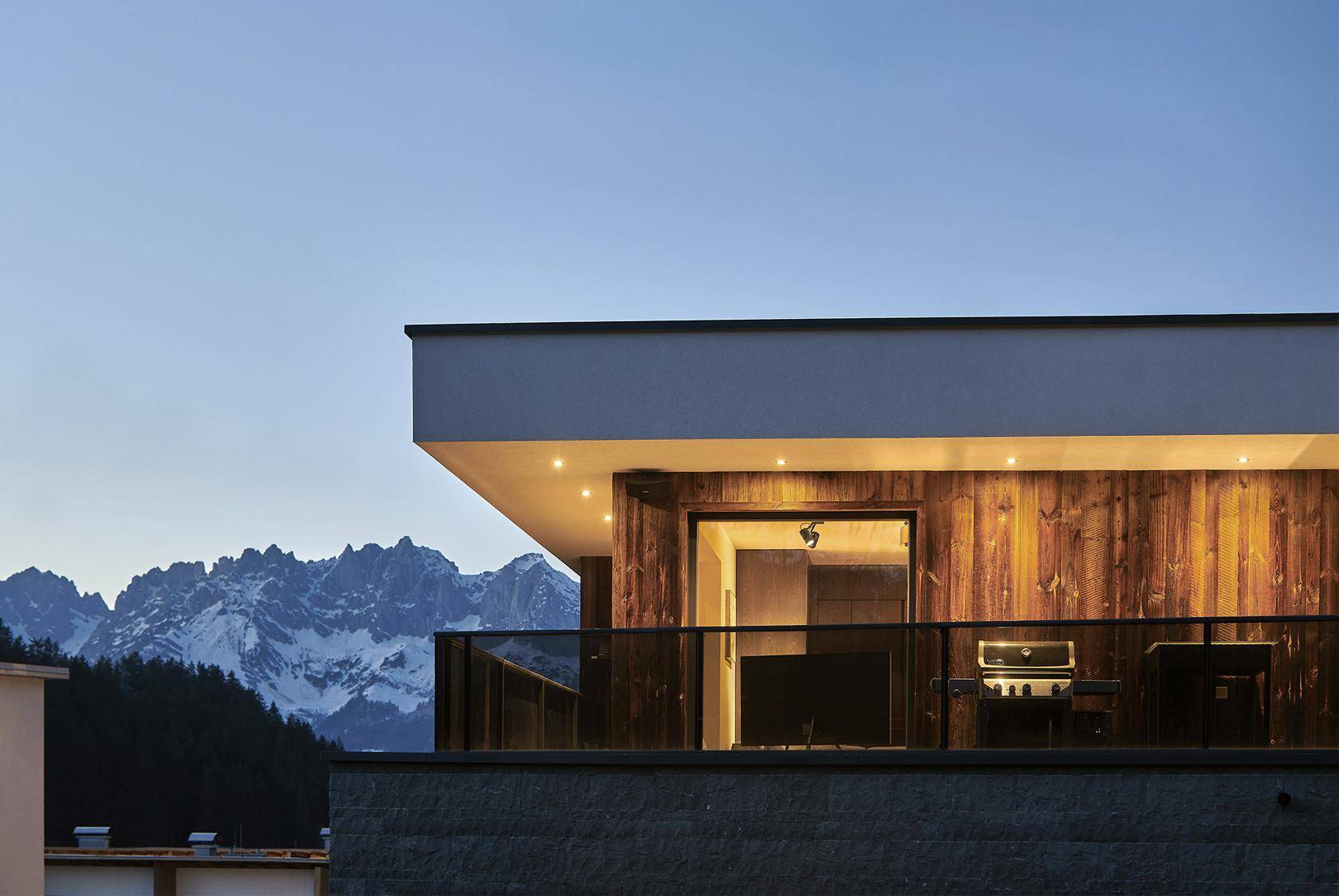 Geräumiger Balkon mit Grillbereich und atemberaubendem Blick auf die umliegende Bergwelt.