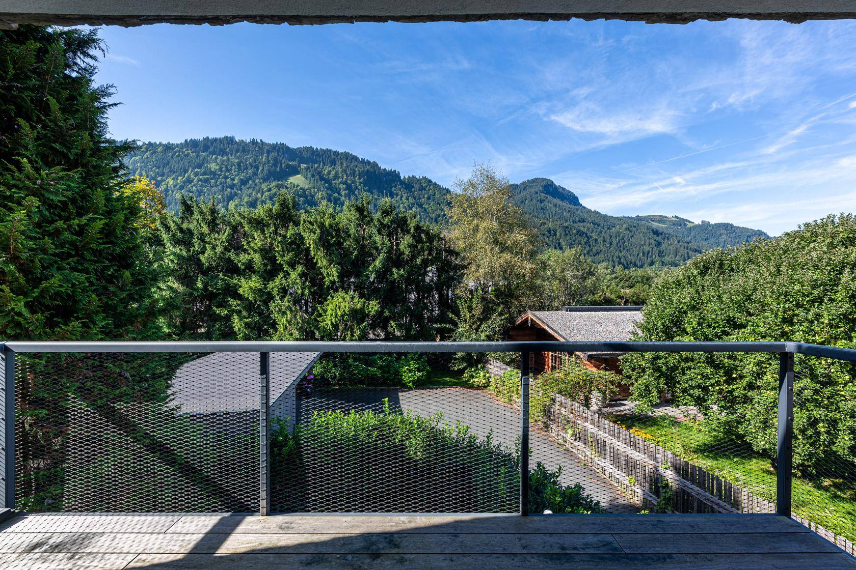 Balkon mit Metallgeländer und weitem Blick auf die umliegende Berglandschaft.
