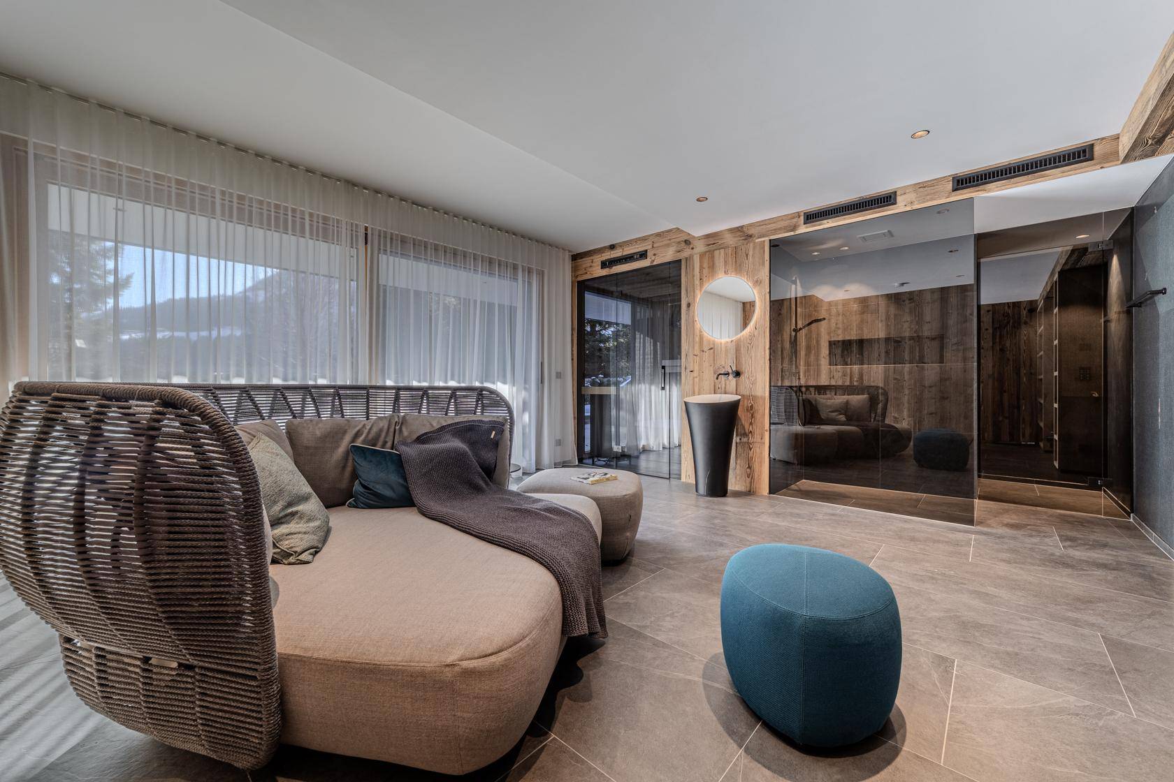 Exklusiver Wellnessbereich mit großem Daybed, modernem Waschbecken und Sauna.