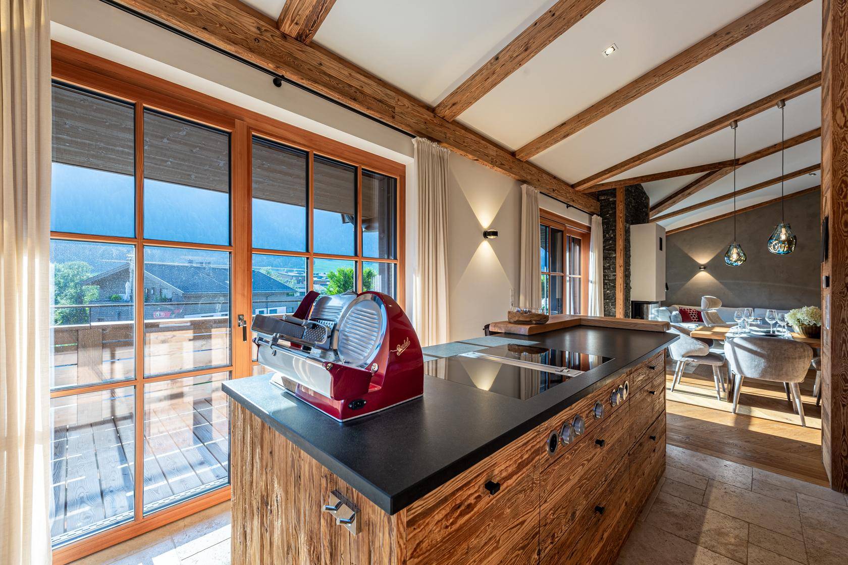 Helle Holzküche mit Kochinsel, modernen Geräten und Zugang zur Terrasse.