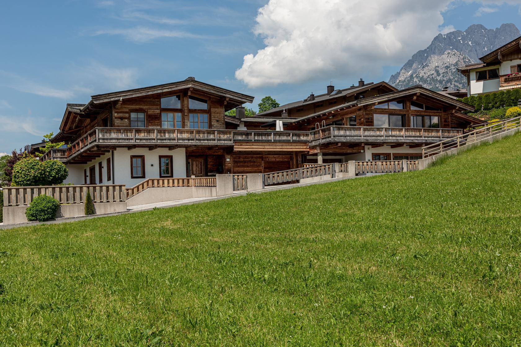 Traditionelles Holzchalet mit mehreren Balkonen und Blick auf die umliegende Berglandschaft.