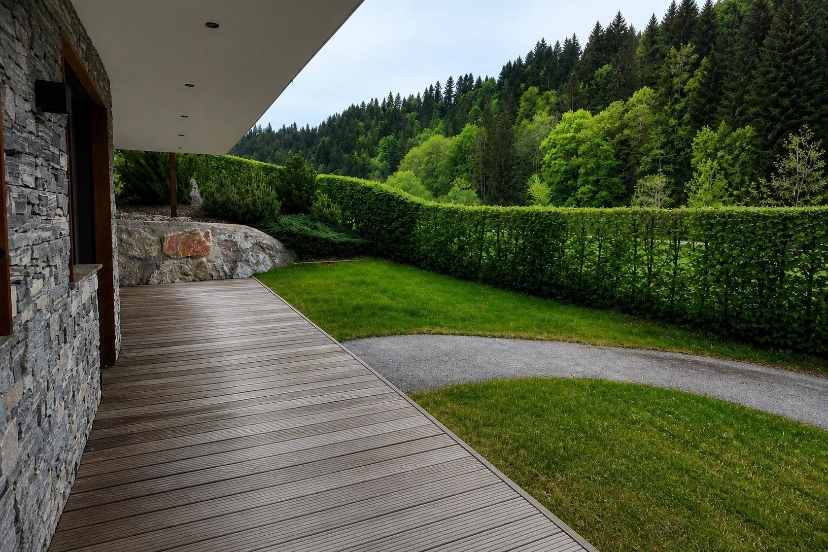 Geräumige Holzterrasse mit Blick auf die grüne Landschaft und bewaldete Hügel, perfekt für Outdoor-Aktivitäten.