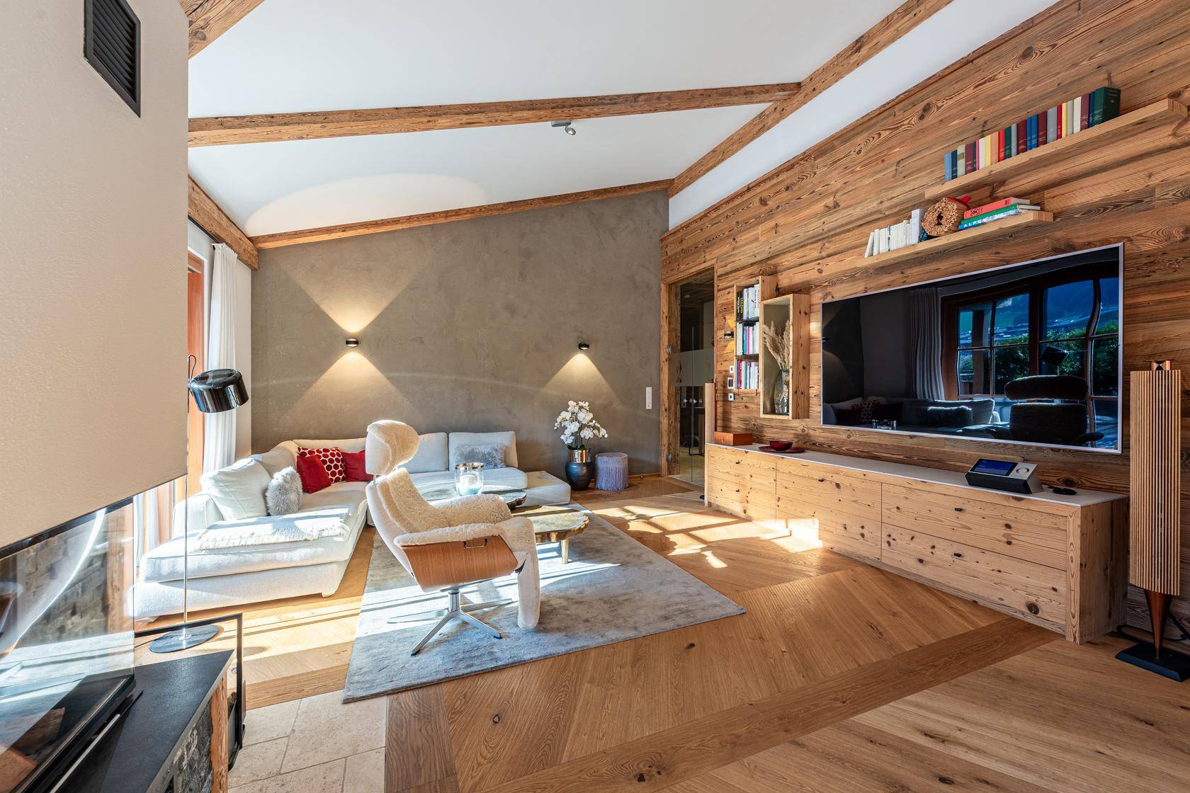 Helles Wohnzimmer mit Holzwänden, Kamin und bequemer Couch für entspannte Abende.