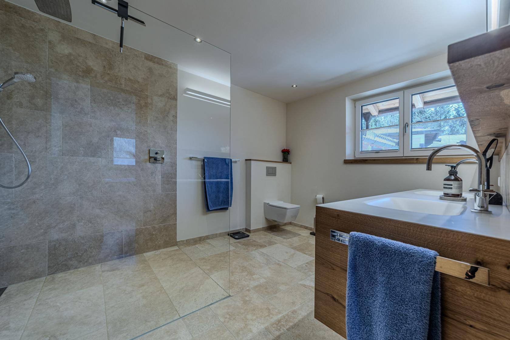 Modernes Badezimmer mit ebenerdiger Dusche, Einzelwaschbecken und Fenster für Tageslicht.
