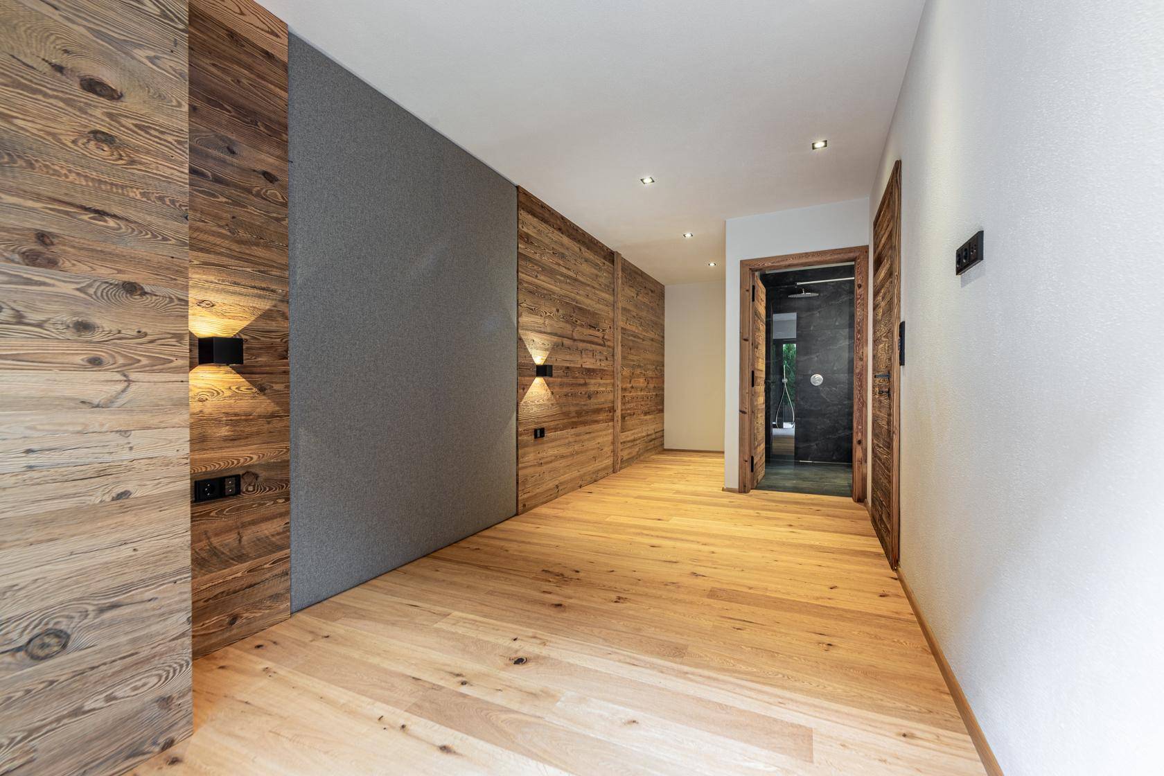 Flur mit Holzboden und Zugang zu einem modernen Badezimmer.