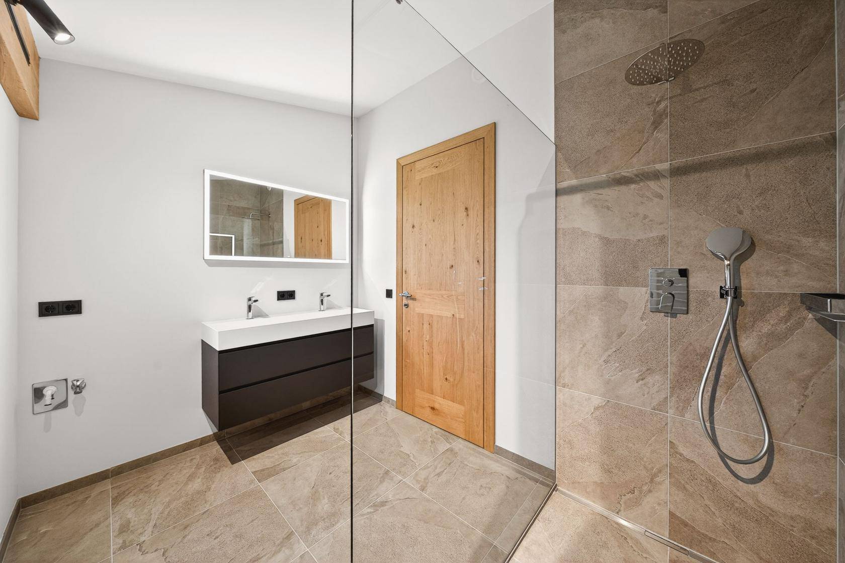 Modernes Badezimmer mit Doppelwaschbecken, großer begehbarer Dusche und Fliesenboden.