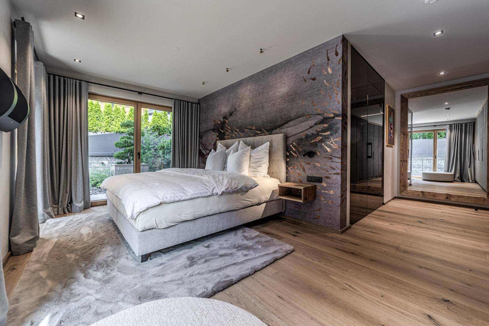 Geräumiges Schlafzimmer mit modernem Design, Holzboden und Zugang zum Außenbereich.