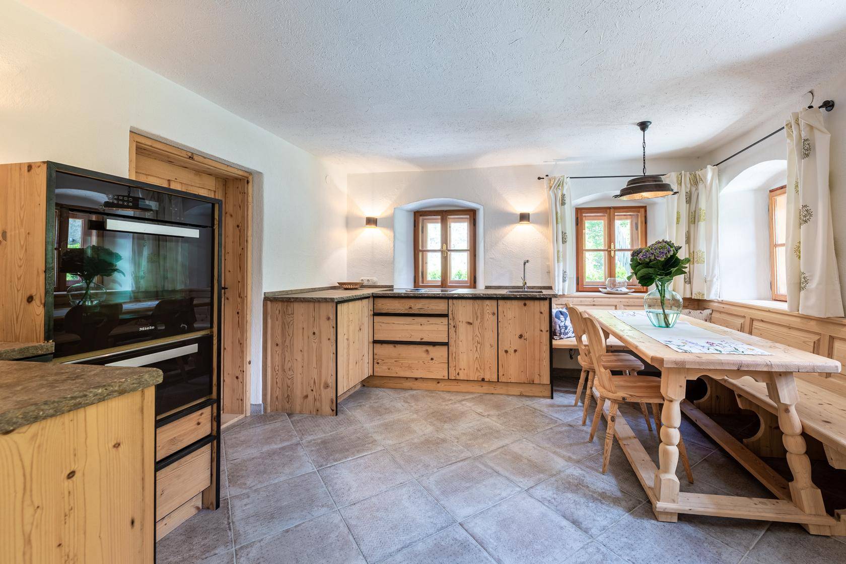 Traditionelle Küche im Landhausstil mit Holzeinbauten und gemütlicher Essecke.