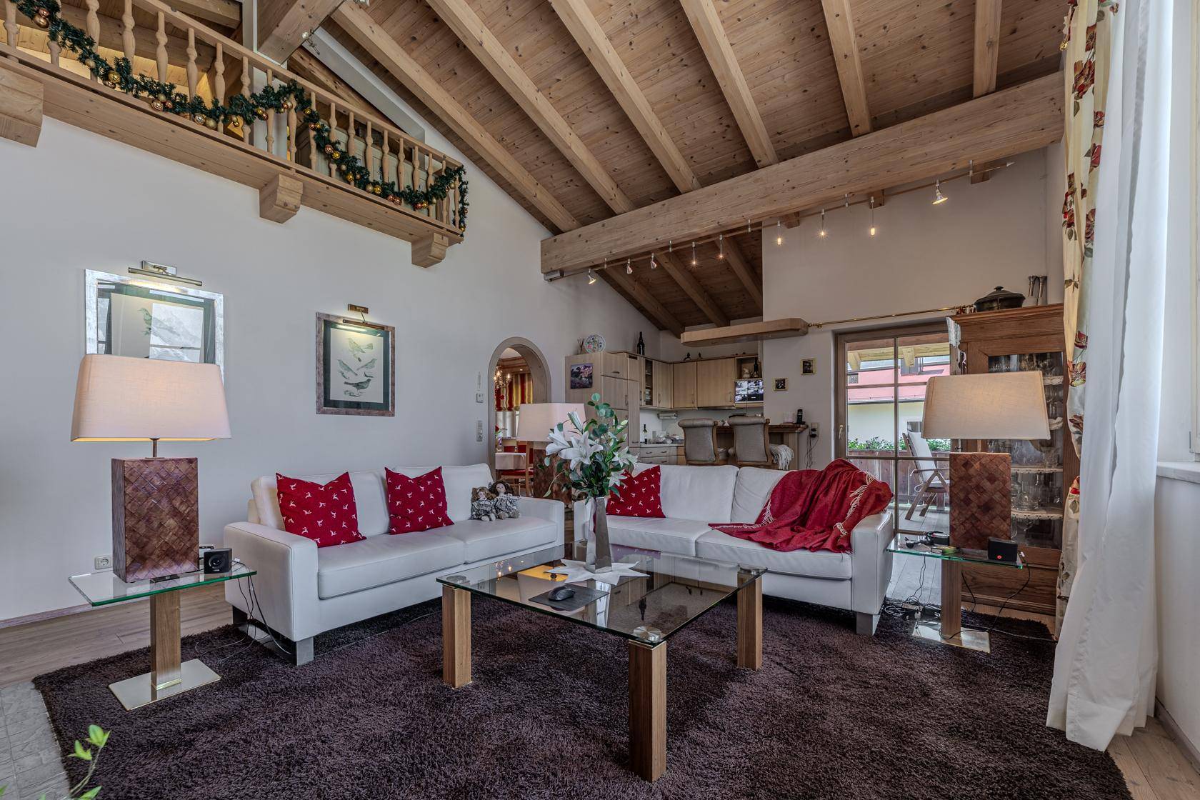 Gemütliches Wohnzimmer mit hohen Holzdecken, bequemen Sofas und festlicher Dekoration.