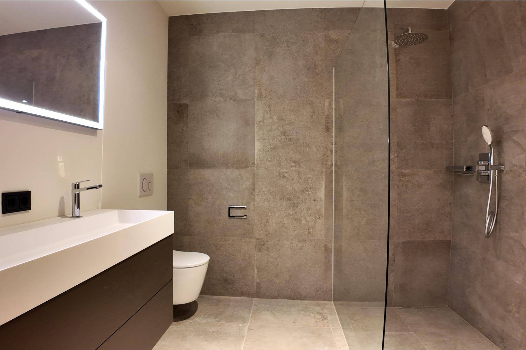 Modernes Badezimmer mit großformatigen Fliesen, einer begehbaren Dusche und einem stilvollen Waschtisch.