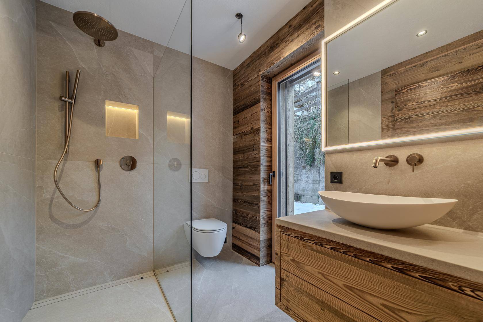 Elegantes Badezimmer mit begehbarer Dusche, stilvollem Waschtisch und Holzwandverkleidung für eine warme Atmosphäre.