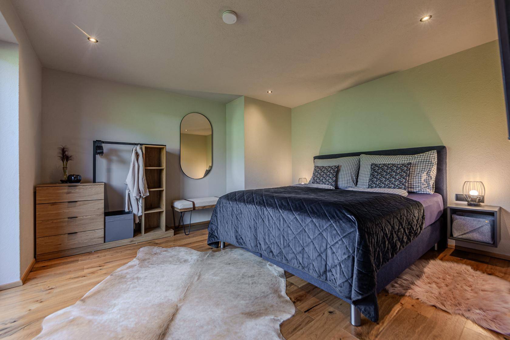 Geräumiges Schlafzimmer mit Holzboden, moderner Einrichtung und viel Stauraum.