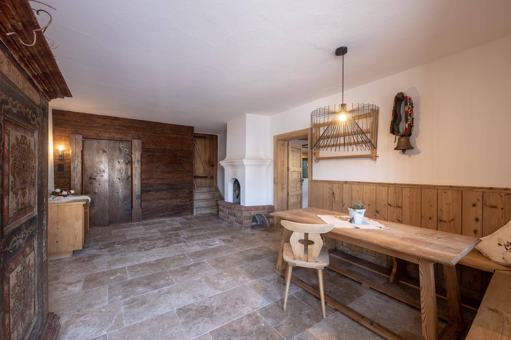Gemütlicher Essbereich mit Fliesenboden, Kamin und traditionellen Holzmöbeln.