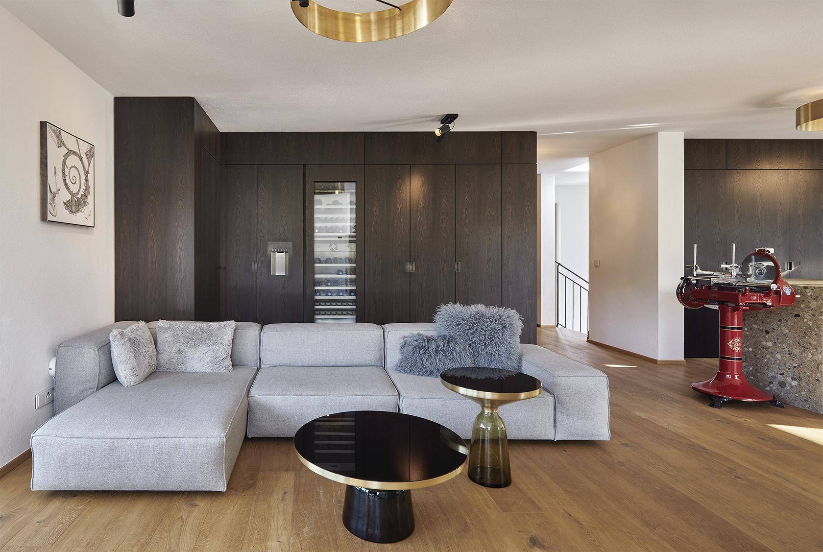 Gemütlicher Wohnbereich mit großem Ecksofa, Holzboden und integriertem Weinkühlschrank.