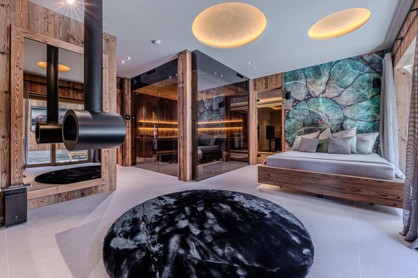Luxuriöses Schlafzimmer mit integrierter Sauna, modernem Kamin und stilvoller Dekoration.