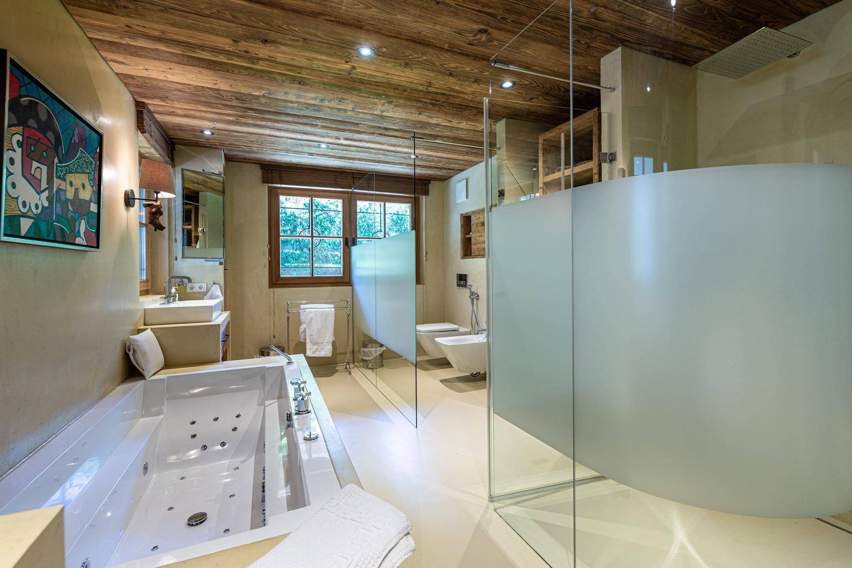 Luxuriöses Badezimmer mit Whirlpool-Badewanne, begehbarer Dusche, Doppelwaschbecken und Holzdecke.