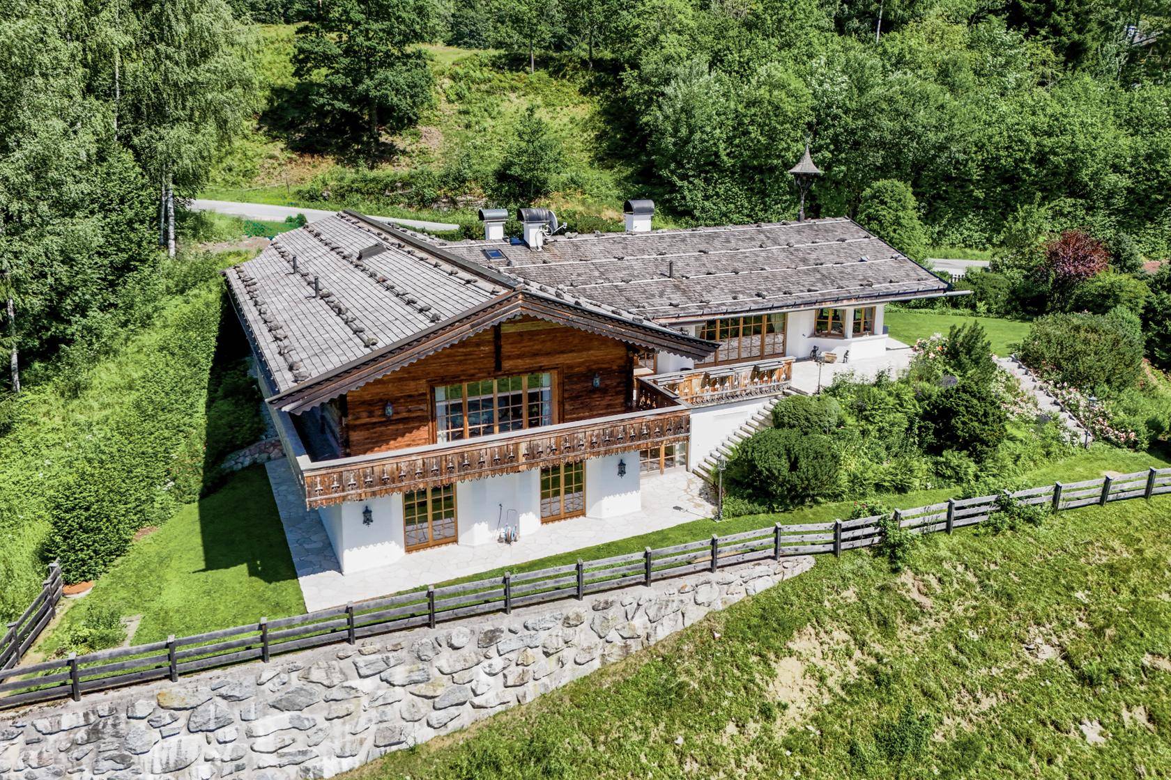 Alpenländisches Haus mit traditioneller Holzfassade, Satteldach und umgebender Natur.