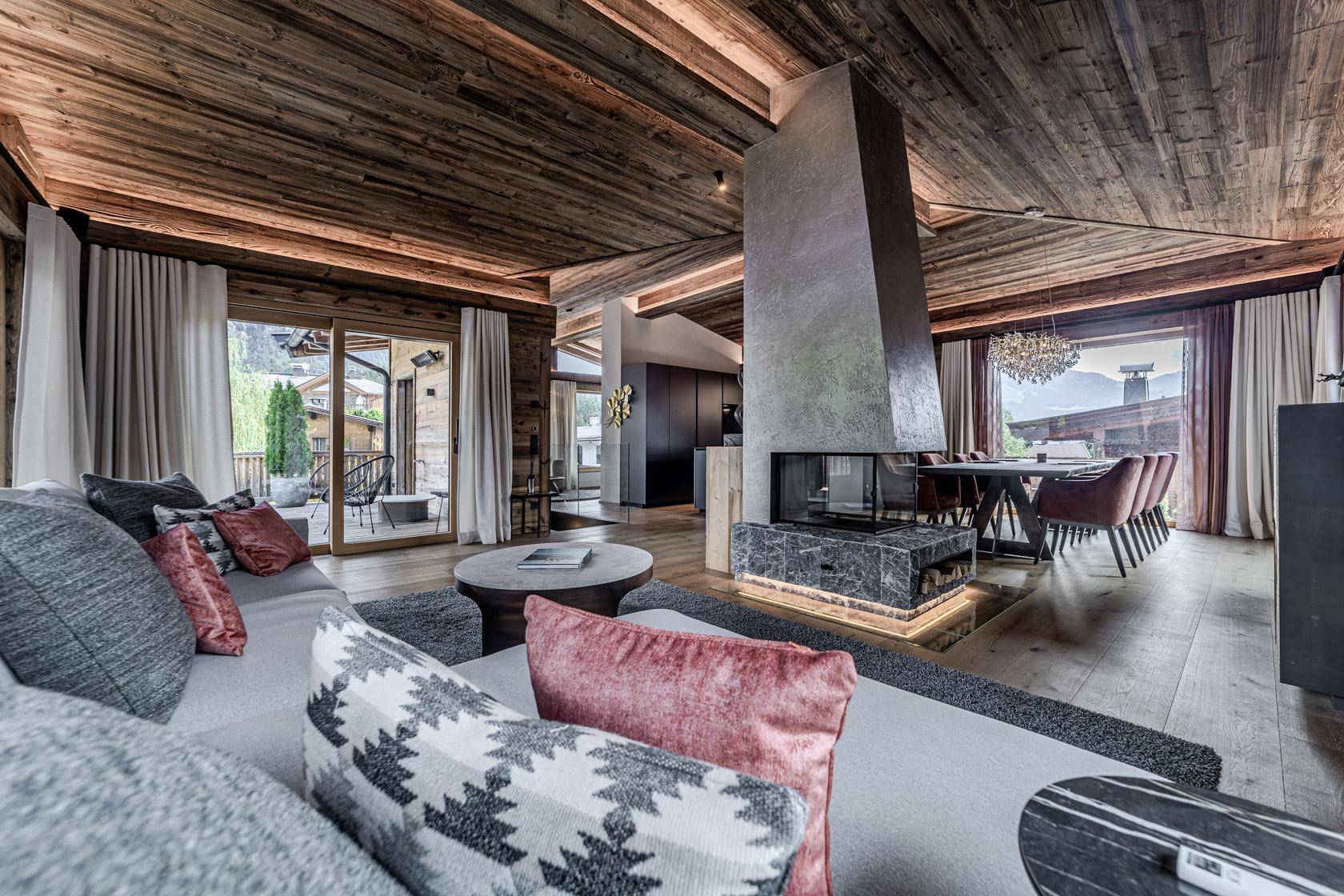 Stilvolles Wohnzimmer mit Kamin, bequemer Sitzecke und Zugang zur Terrasse.