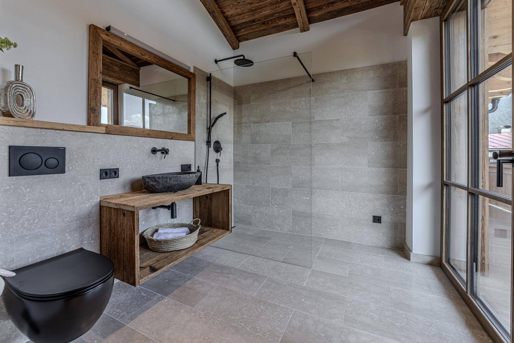 Modernes Badezimmer mit begehbarer Dusche, Holzwaschtisch und wandhängendem WC, hell durch großes Fenster.