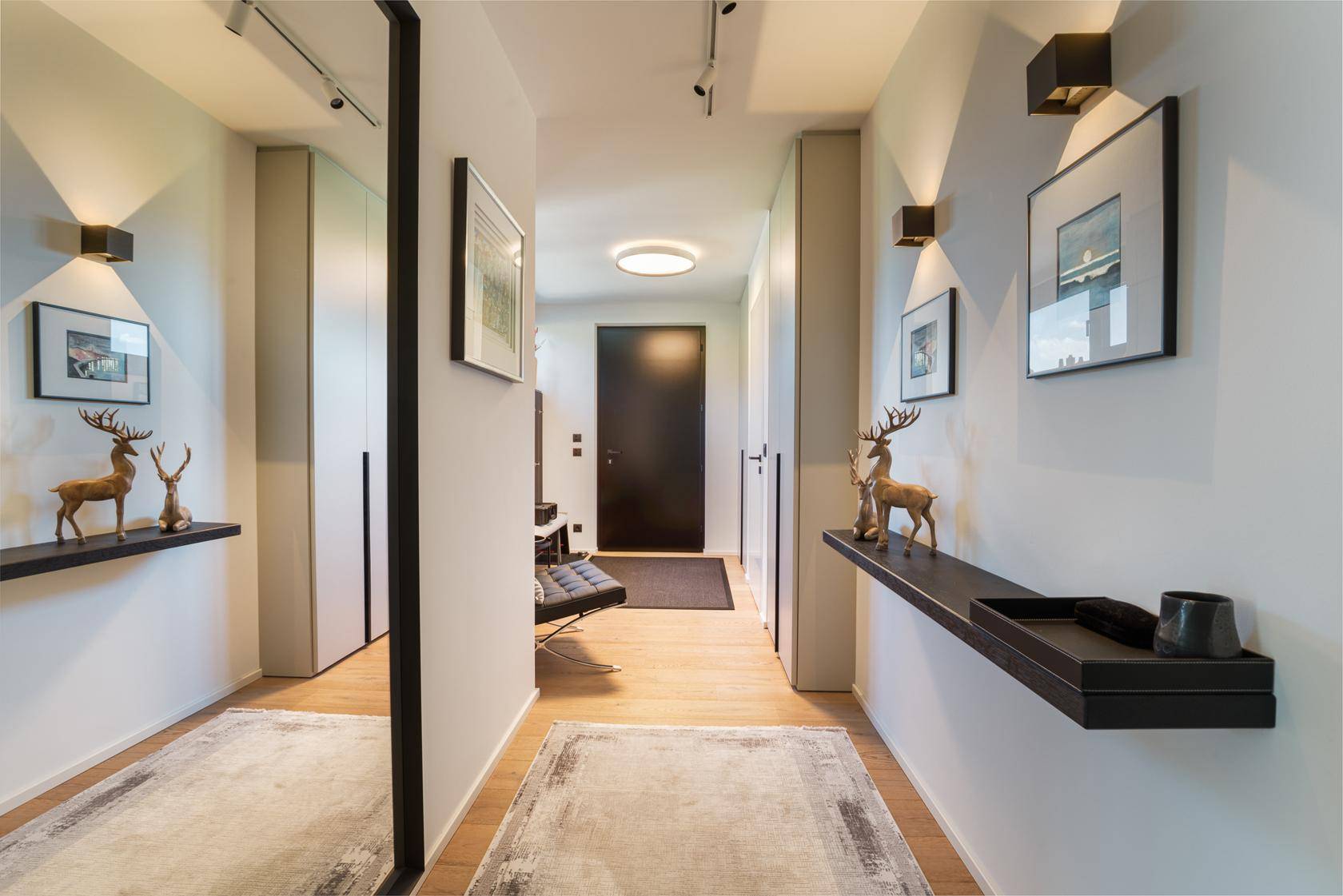 Heller Flur mit Holzboden, Spiegelschrank und moderner Dekoration.
