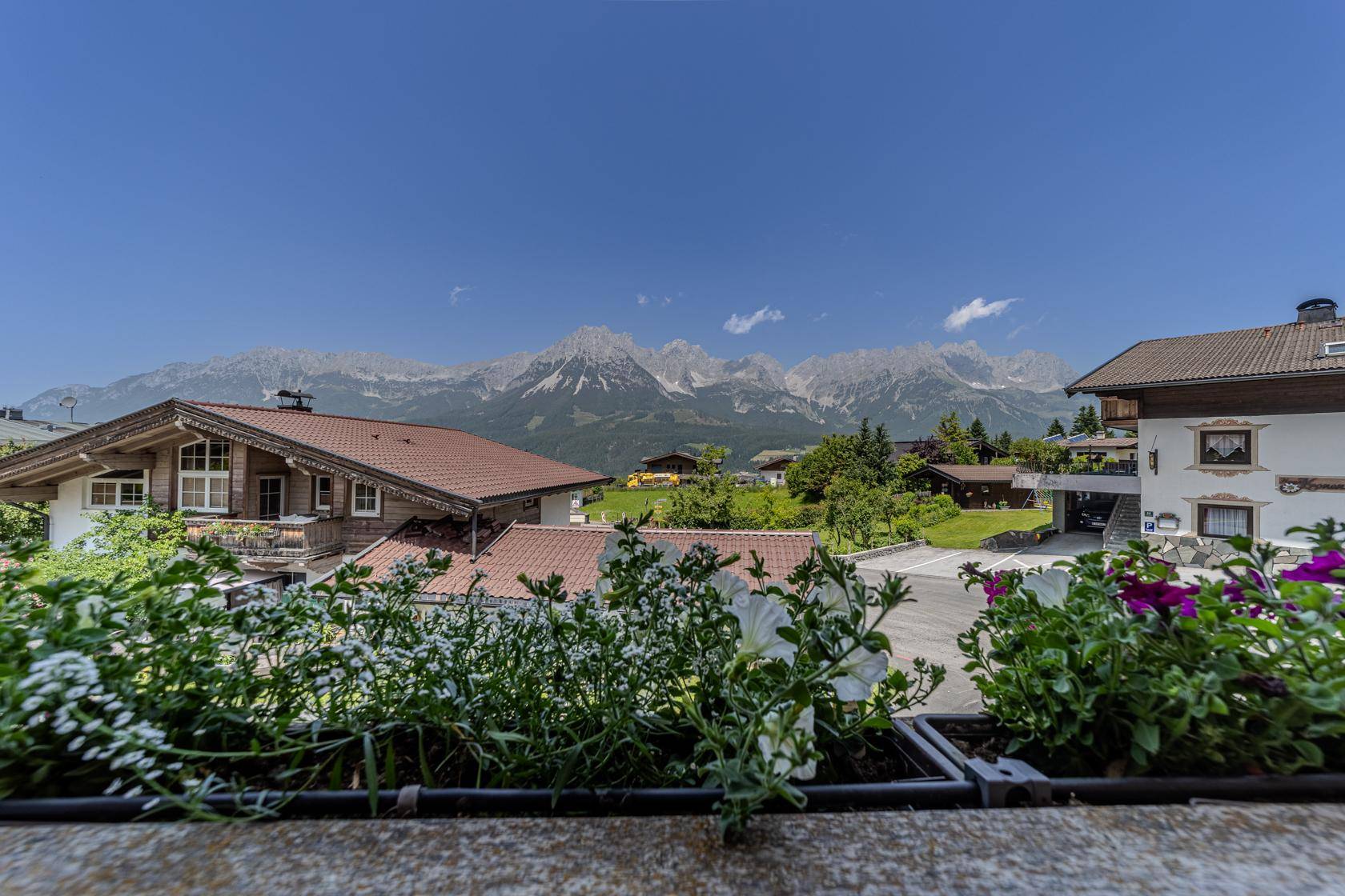 Panoramablick auf die majestätischen Berge und die grüne Landschaft unter blauem Himmel.