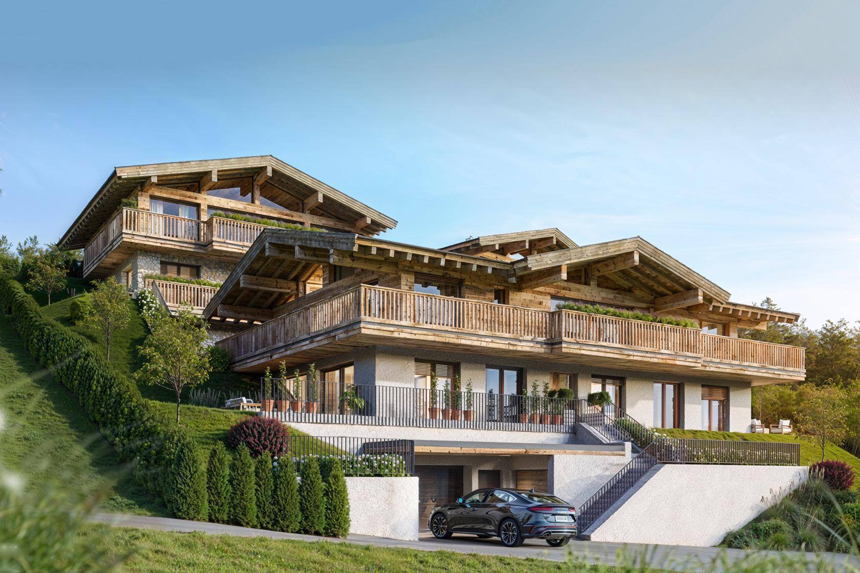 Moderne Chalet-Architektur mit mehreren Balkonen und Terrassen, eingebettet in eine grüne Hanglage.