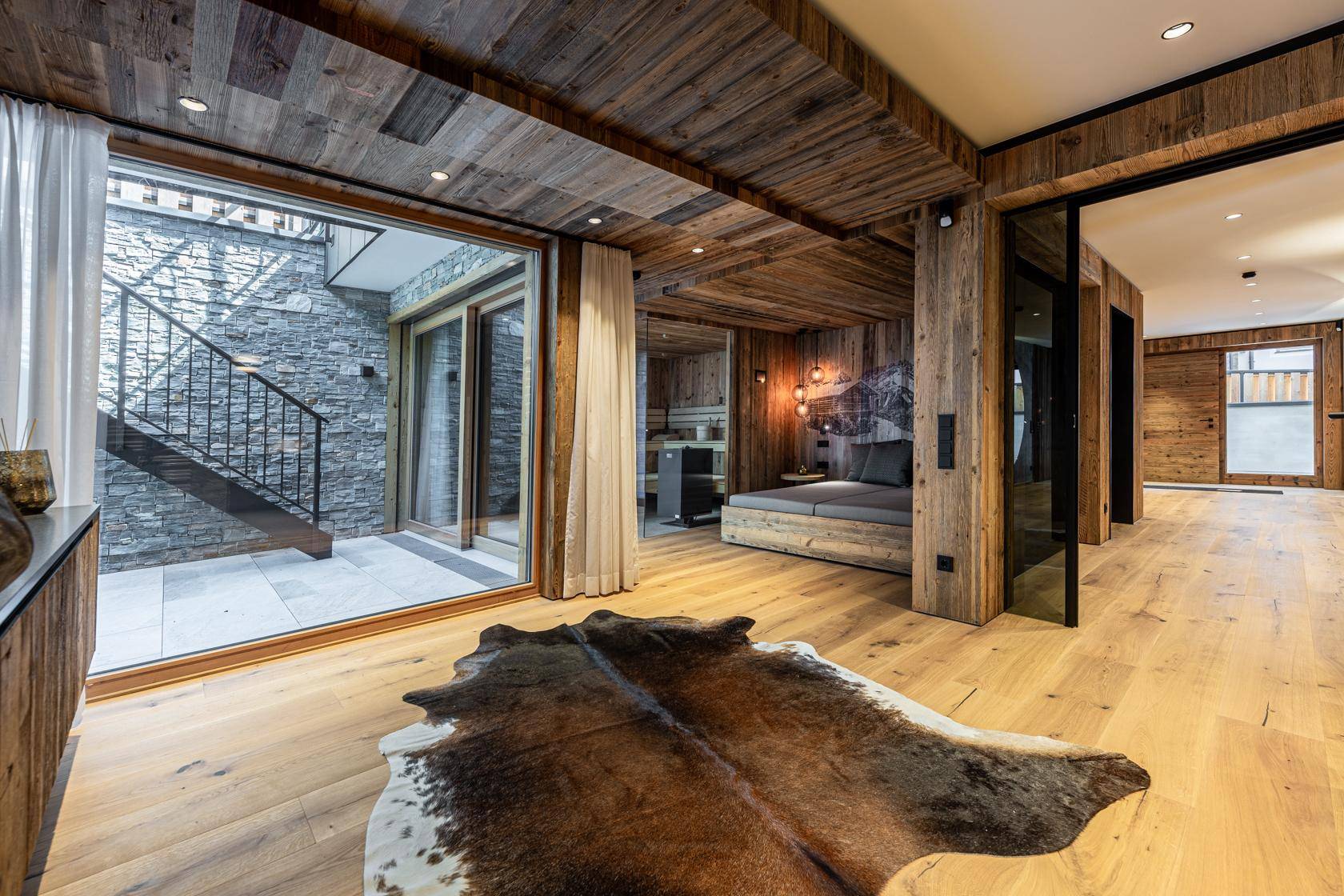 Gemütliches Schlafzimmer mit Holzwänden, Holzboden und direktem Zugang zu einem Steinhof.