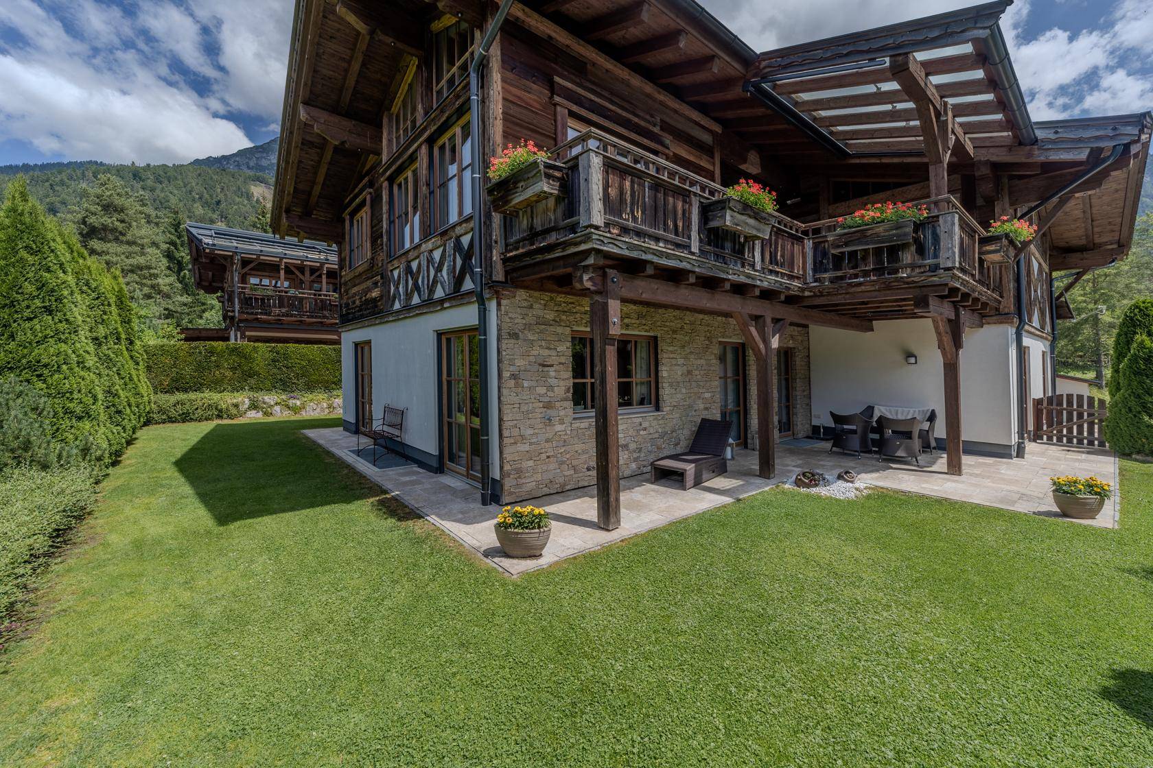 Charmantes Chalet mit gepflegtem Garten, Terrasse und Balkonen im alpinen Stil.