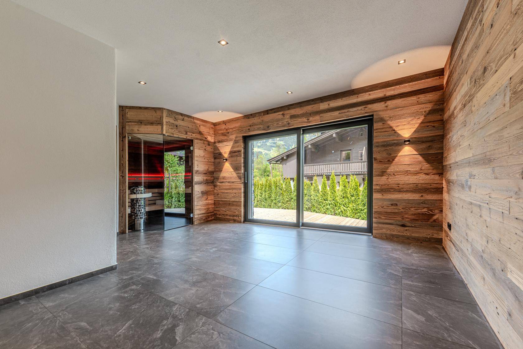 Heller Wellnessbereich mit Sauna und Zugang zur Terrasse, ideal für Entspannung.