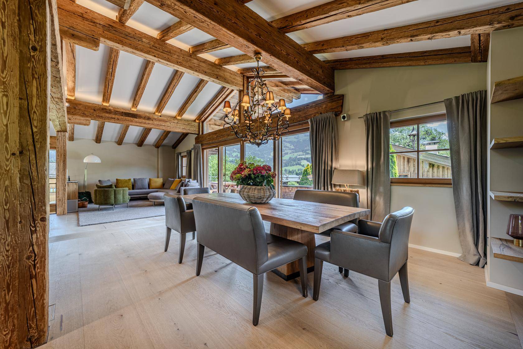 Heller Essbereich mit Holztisch, modernen Stühlen und Kronleuchter.