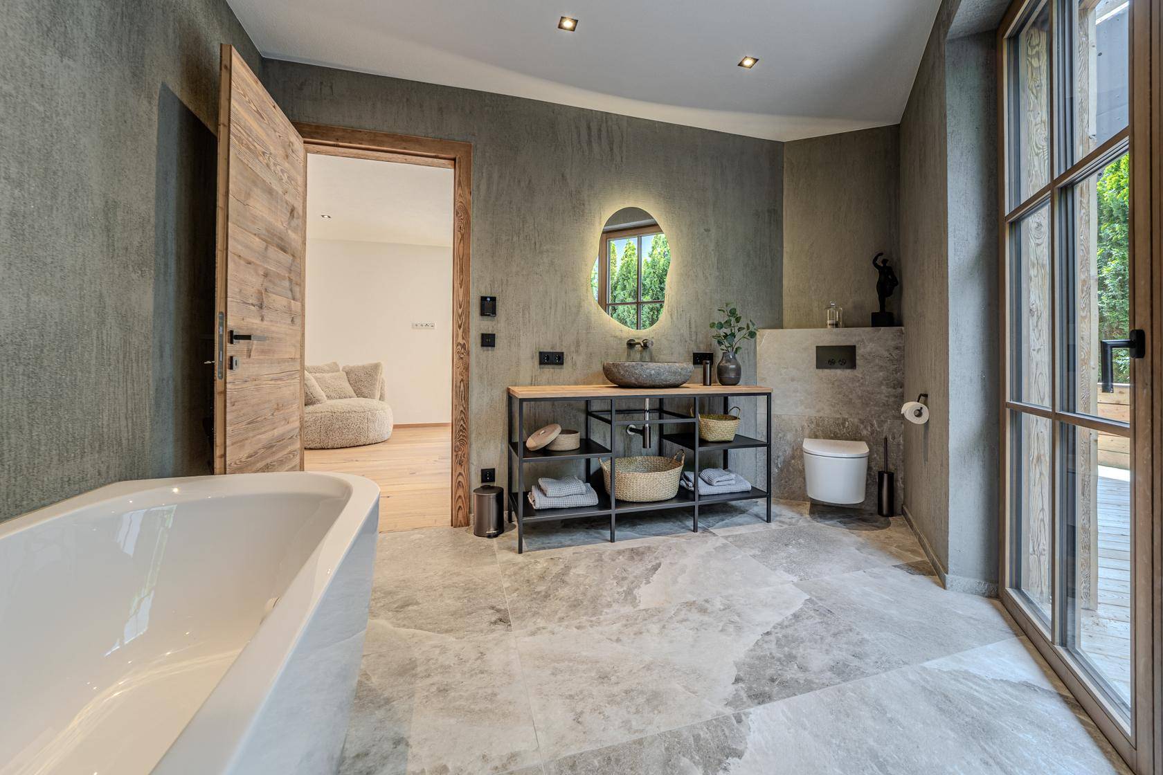 Modernes Badezimmer mit freistehender Badewanne, stilvollem Waschtisch und großen Fenstern.