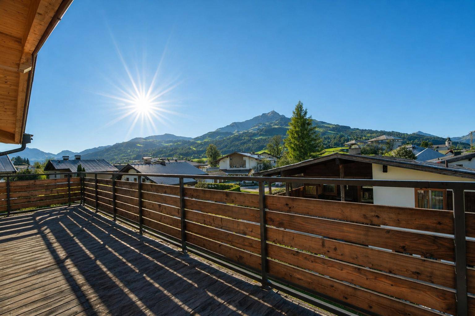 Geräumiger Holzbalkon mit stabiler Brüstung und weitem Blick auf die umliegende Bergwelt.