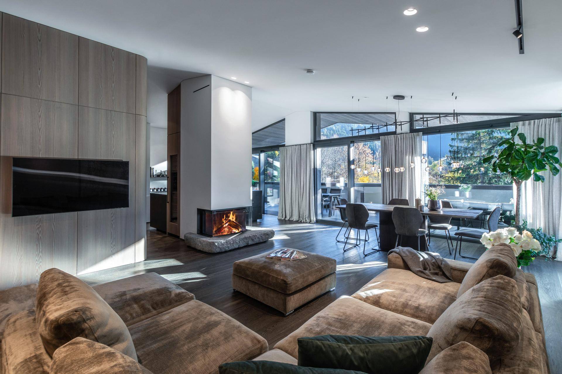 Geräumiger Wohnbereich mit gemütlicher Sitzecke, modernem Kamin und Zugang zur Terrasse.
