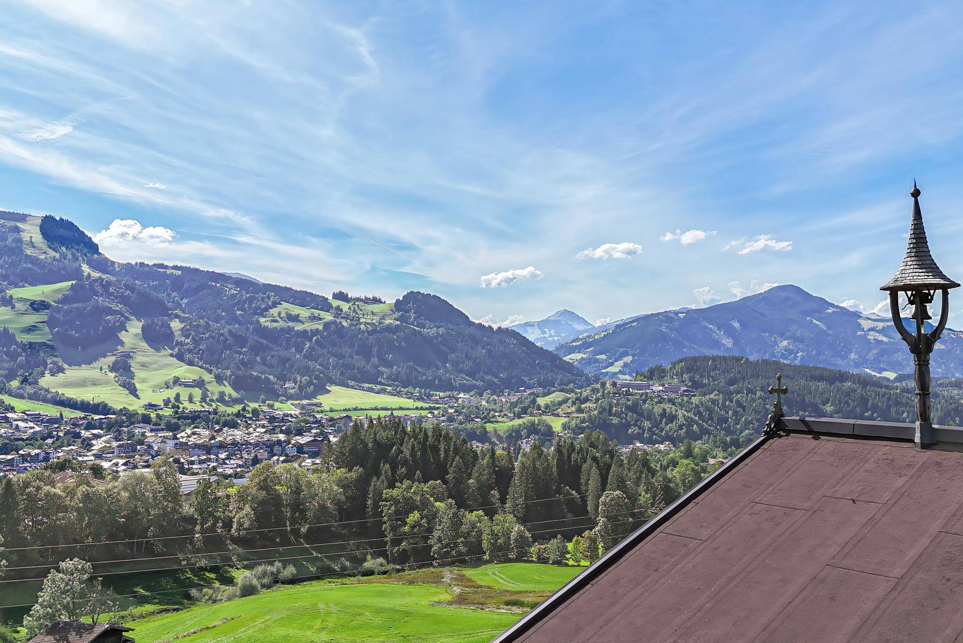 Weitläufiger Panoramablick über grüne Täler und Berge unter einem strahlend blauen Himmel.