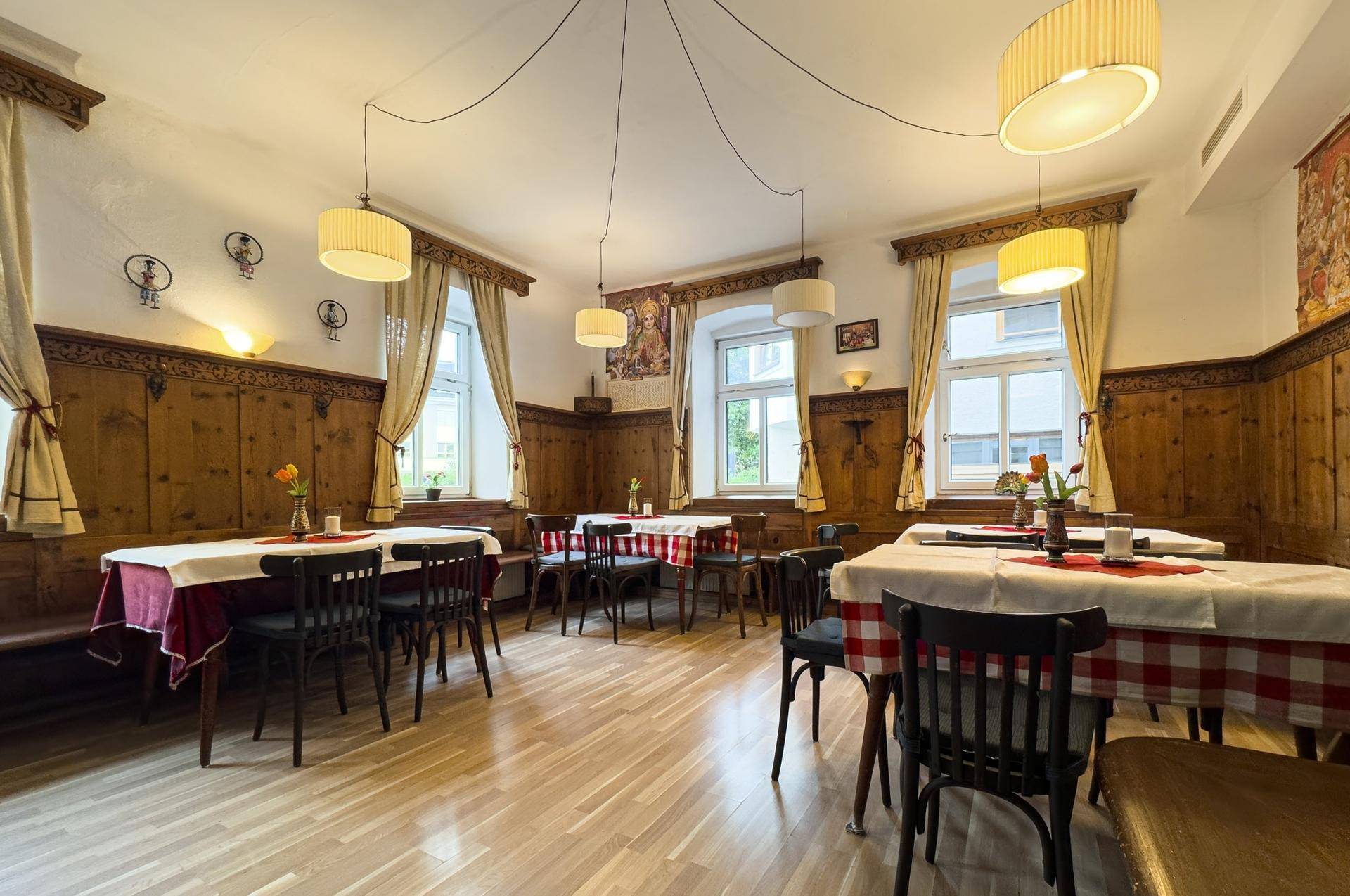 Heller Speisesaal im traditionellen Stil mit Holzelementen, Tischen und Stühlen sowie natürlichem Licht.